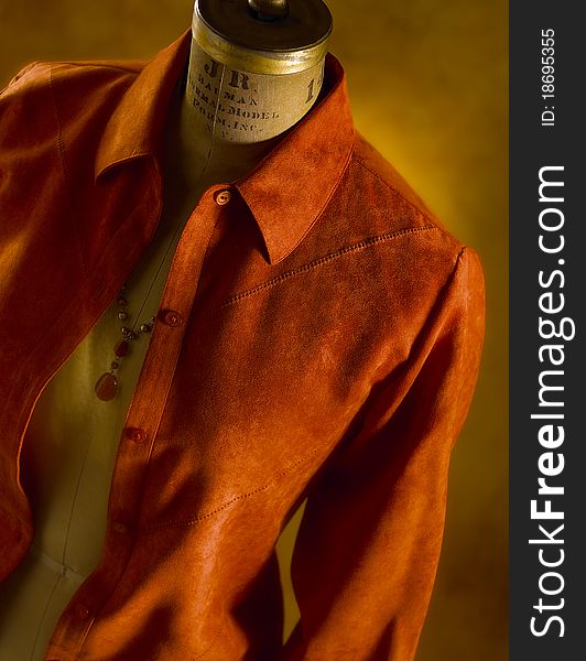 Women's orange jacket shot on a headless mannequin with dramatic light. Women's orange jacket shot on a headless mannequin with dramatic light.