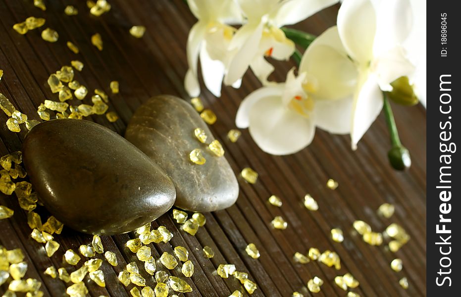 Stones, bath salts and orchid flower on wooden