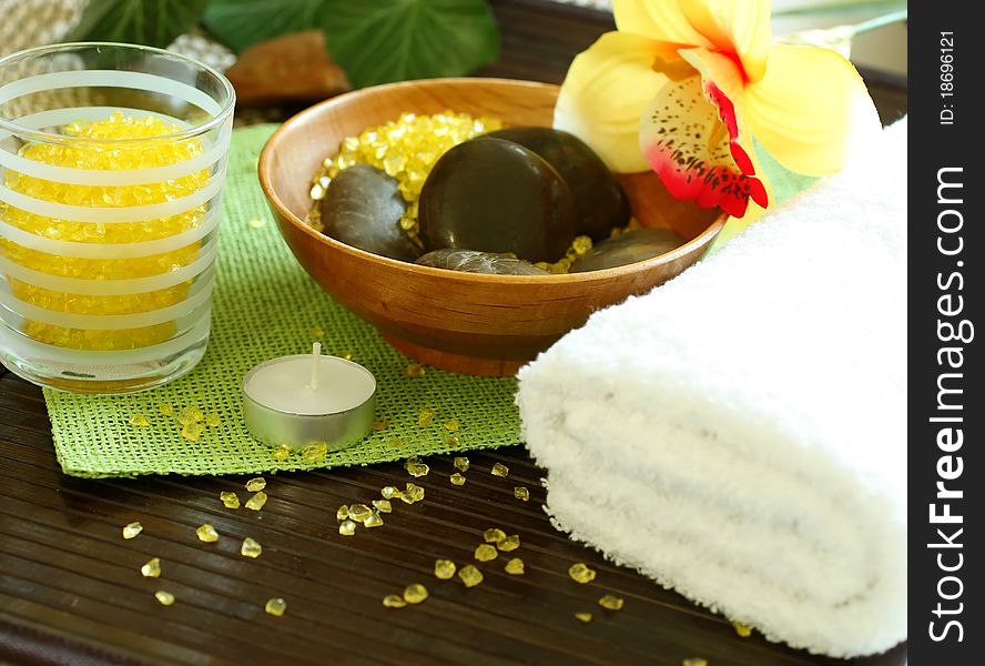 Spa composition of towel, stones and candle on wooden