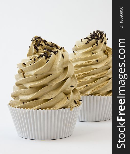 Close-up of two coffee meringues with chocolate chips on white background
