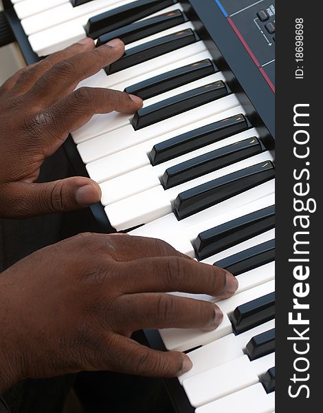 Black man playing music on electronic organ. Black man playing music on electronic organ