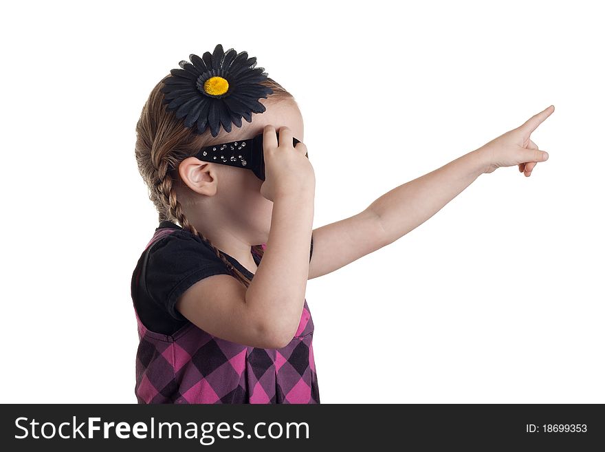 A girl pointing up in the are at something, as she grabs at her sunglasses to remove them. A girl pointing up in the are at something, as she grabs at her sunglasses to remove them.