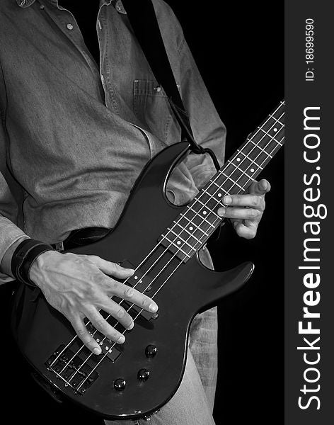 Man in jeans playing electrical bass guitar, black and white. Man in jeans playing electrical bass guitar, black and white