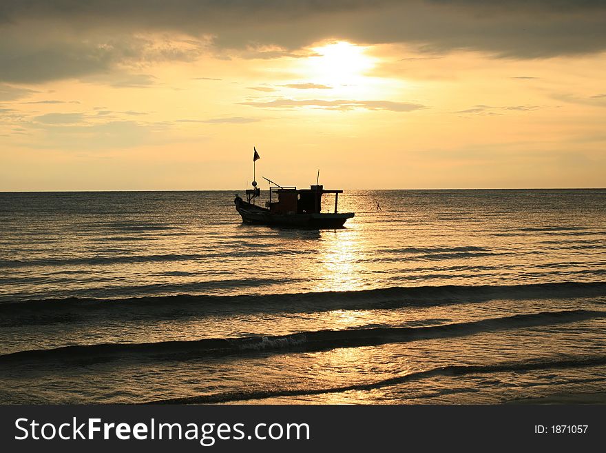 A fisherman boat in background of a sun set. A fisherman boat in background of a sun set