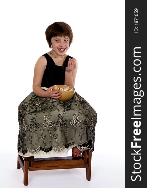 Adorable dressed up girl eating a bowl of party snacks. Adorable dressed up girl eating a bowl of party snacks.