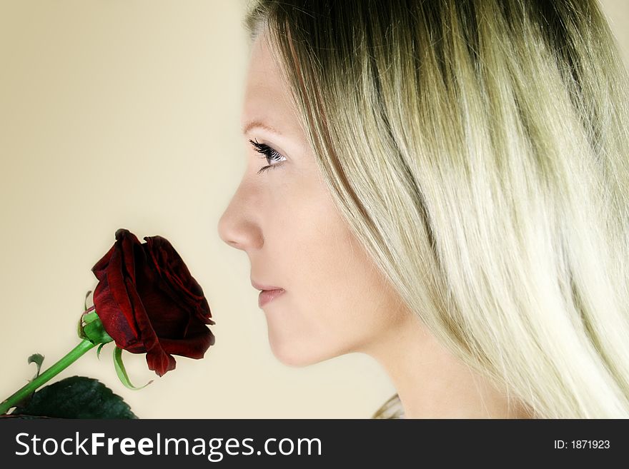 Portrait of a fresh, beautiful young blond woman with a red rose in her hand - valentine Â´s day