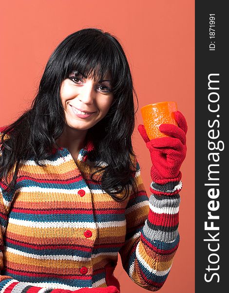 Beautiful woman in sweater dress with orange cup of tea