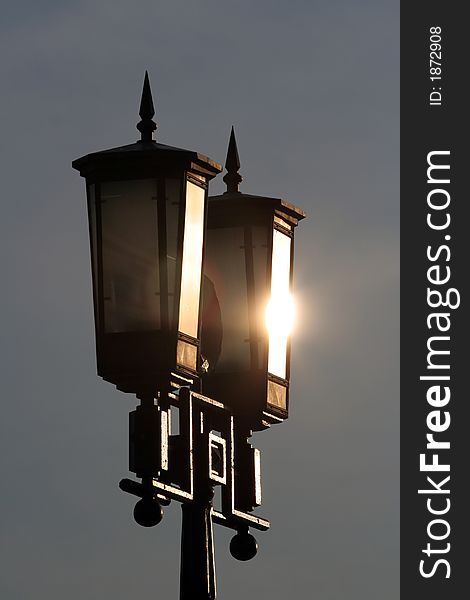 Street lamp in park with sun glare
