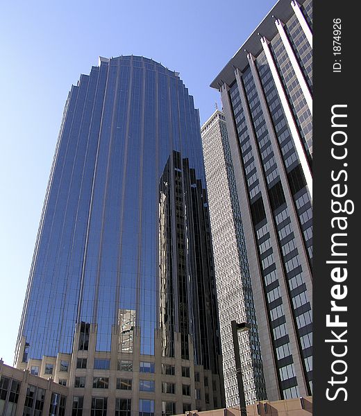 Downtown Boston skyscraper with blue sky background and reflections of ajoining building