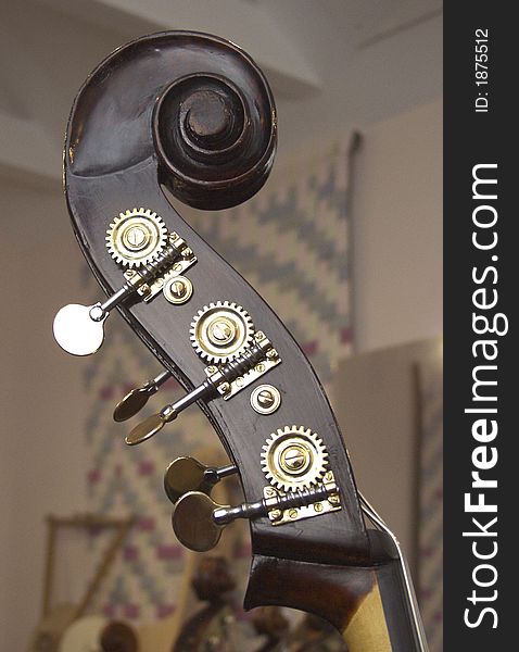 Scroll, volute, tuning gears of a 5-string double-bass. Scroll, volute, tuning gears of a 5-string double-bass