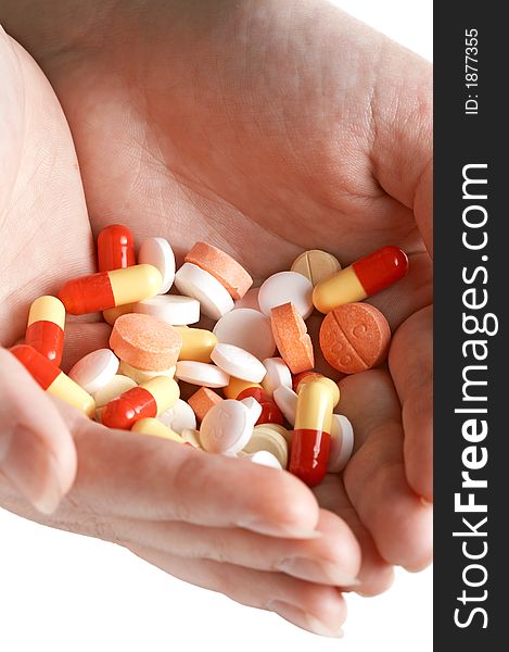 Heap of white. Red, orange pills and capsules in two woman hands. Vertical. Isolated white. Heap of white. Red, orange pills and capsules in two woman hands. Vertical. Isolated white.