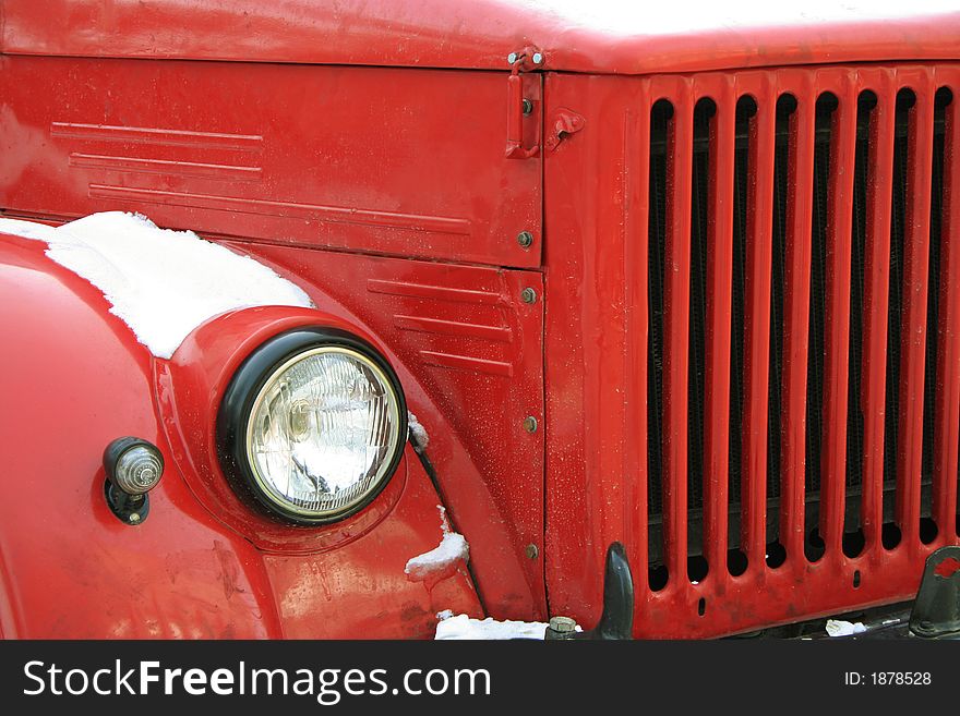 The red old car under a snow