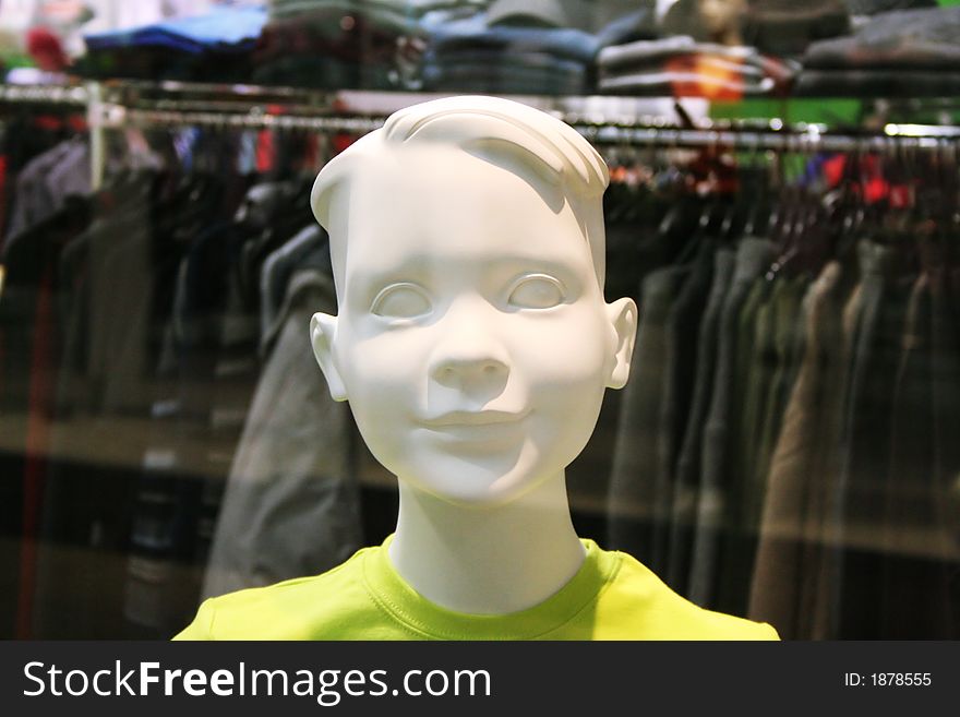 Dummy with a smile behind glass in shop