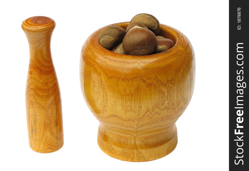 Wooden  mortar with pestle standing near by with chestnuts inside the bowl on white background. Wooden  mortar with pestle standing near by with chestnuts inside the bowl on white background