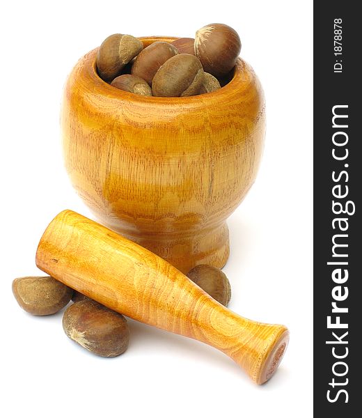 Wooden  mortar with pestle lying outside with chestnuts on white background. Wooden  mortar with pestle lying outside with chestnuts on white background