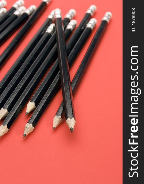 Black Pencils set against a Red Background.