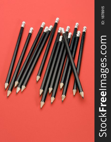 Black Pencils set against a Red Background.