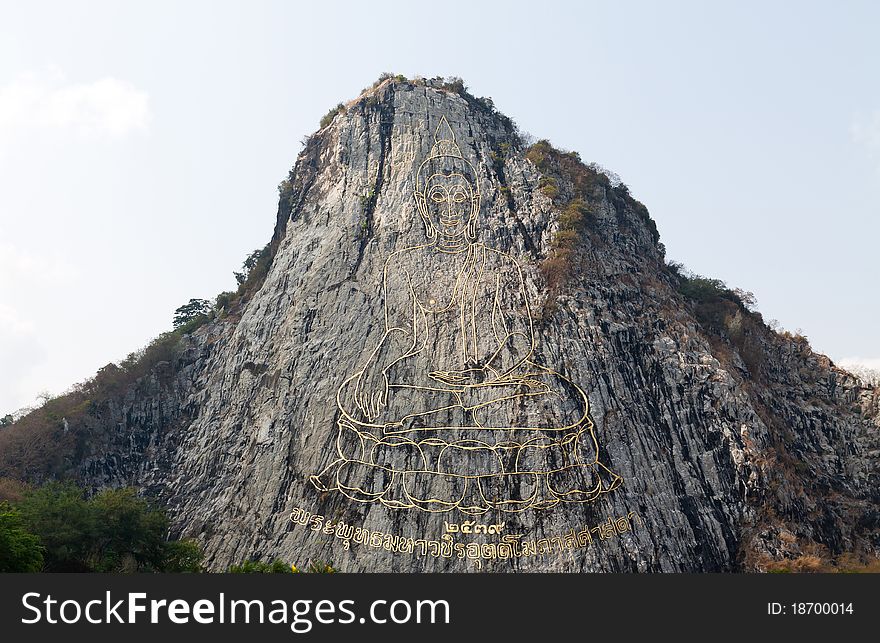 Gold painting of buddha statue on cliff at Cheechan temple Chonburi,Thailand