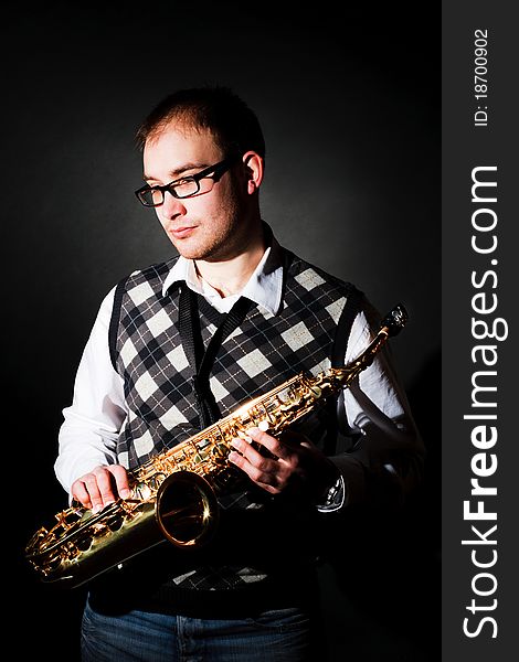 Portrait of a man with a saxophone on black