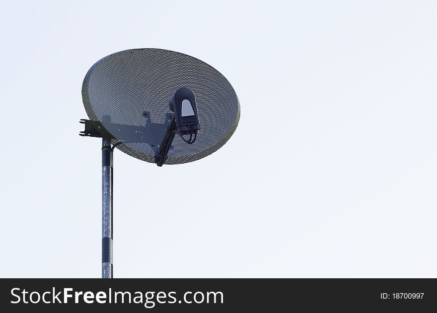 Satellite dish on mast with sky background