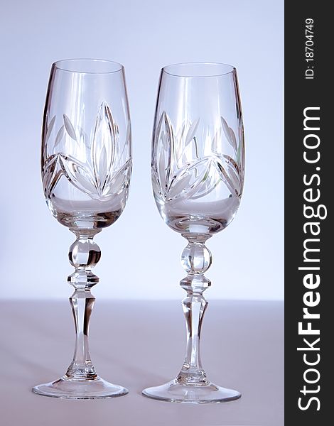 Two crystal wedding glasses on a gray background