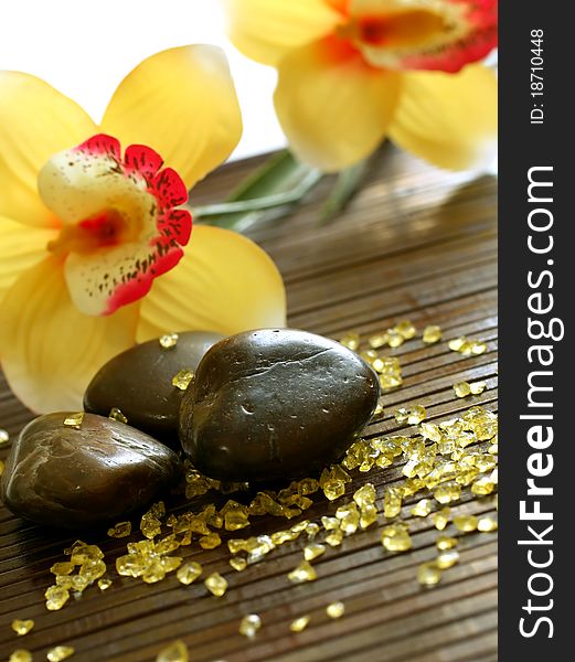 Spa composition of stones, yellow bath salt and flowers