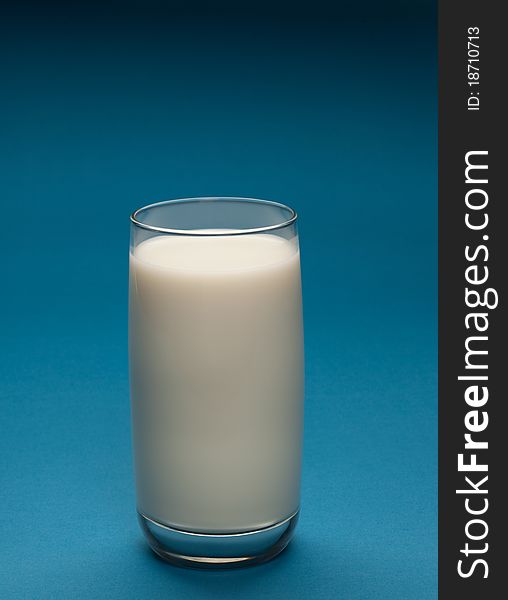 Glass of milk on a blue background.