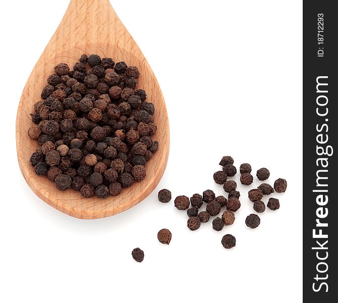 Black peppercorn spice in a wooden spoon and scattered, over white background. Black peppercorn spice in a wooden spoon and scattered, over white background.