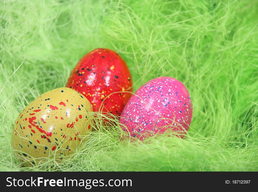Different colored easter eggs in a nest. Different colored easter eggs in a nest.