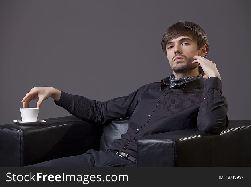 Fashion man sitting in chair with cup coffee. Fashion man sitting in chair with cup coffee