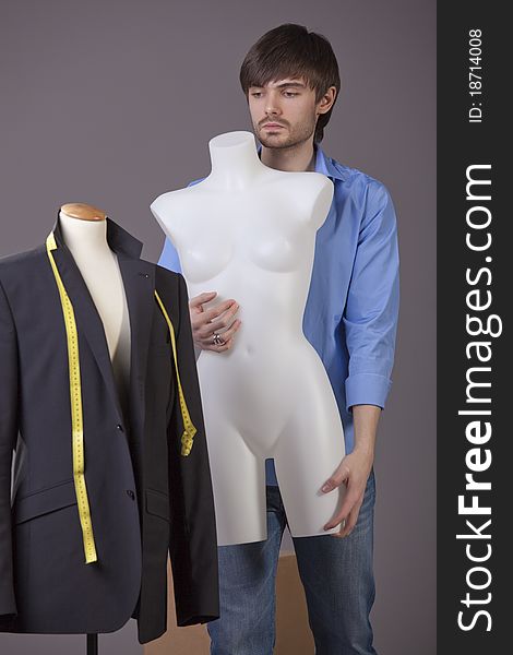 Male tailor with mannequin working in his studio. Male tailor with mannequin working in his studio