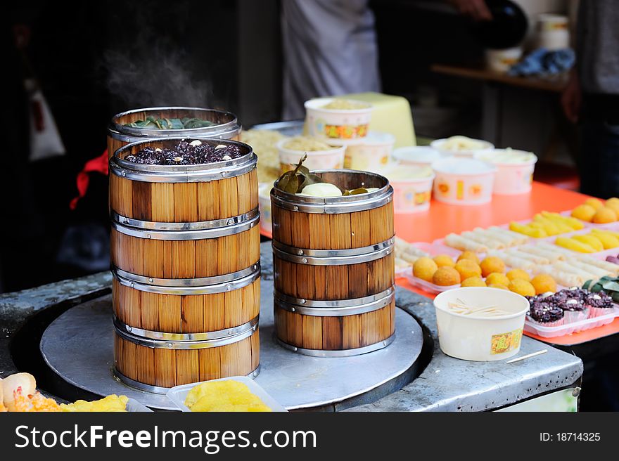 Chinese bamboo steamer with buns, lotus leaves and other dishes. A classic view of Chinese streets.