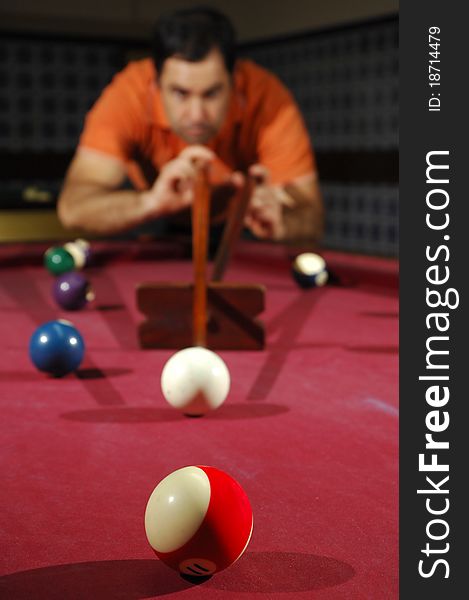 Snooker player taking a long shot across the table (focus on the first ball). Snooker player taking a long shot across the table (focus on the first ball)