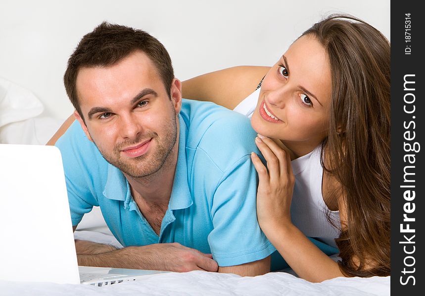 Couple With Laptop In Bedroom