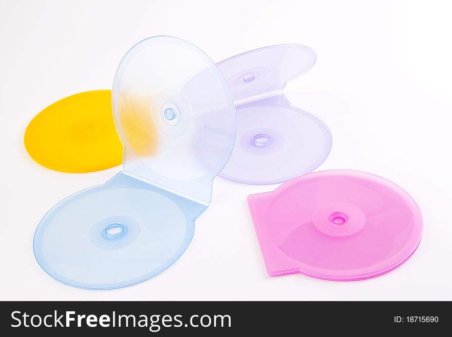 Colorful plastic cd covers spread out on a white background