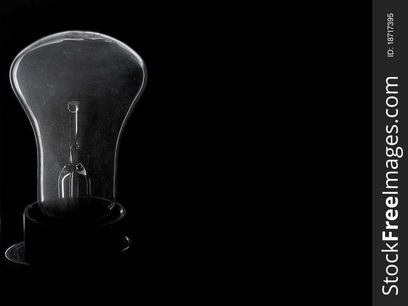 Incandescence bulb on a black background with a poorly transparent flask. Incandescence bulb on a black background with a poorly transparent flask