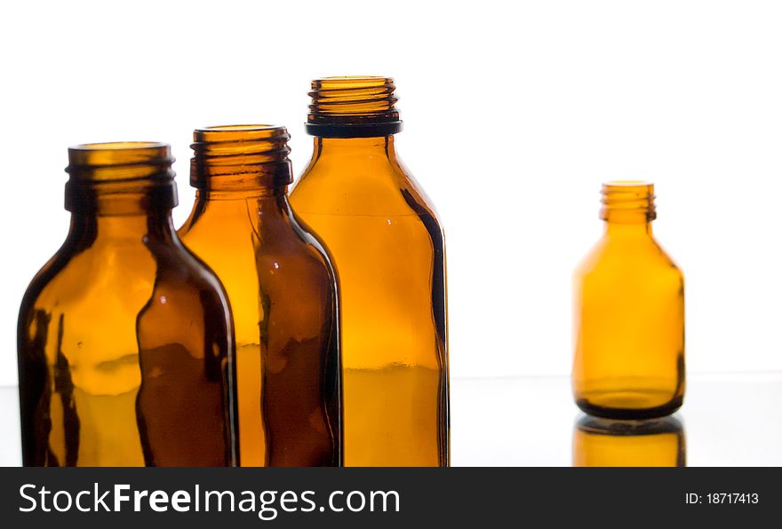 Four yellow glass bottles from under medicines on a white background