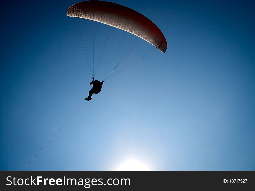 Parachutist flight against the blue sky