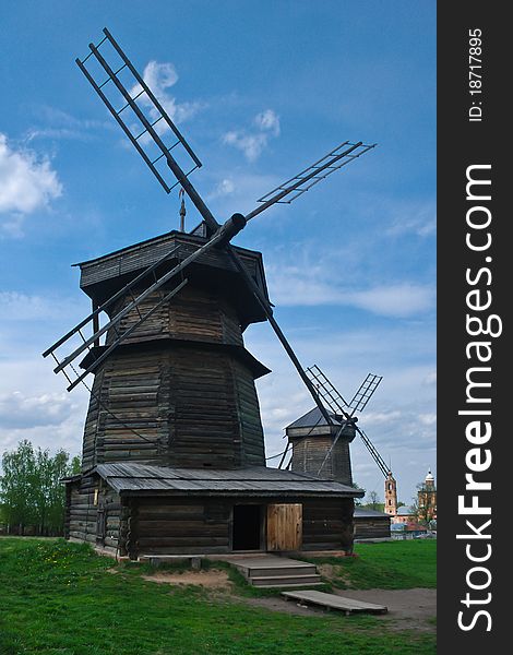 Wooden windmills in warm weather. Green summer lawn. Clear sky. Wooden windmills in warm weather. Green summer lawn. Clear sky.