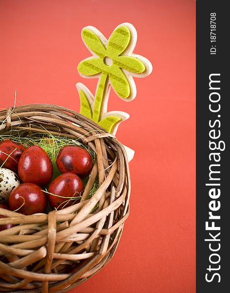 Easter eggs in wicker basket on red background