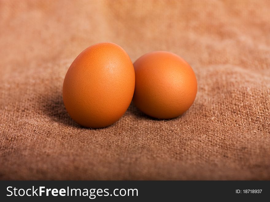 Two eggs on a brown background