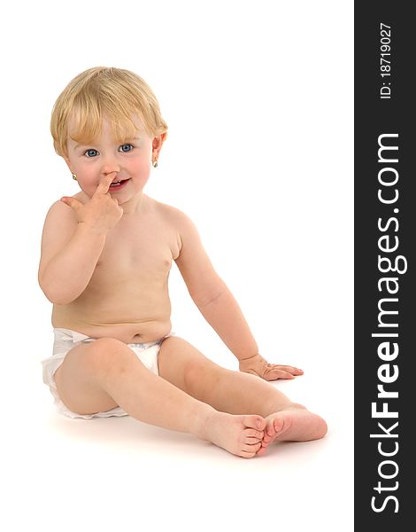 Infant sits and concerning finger personal nose, on white background.