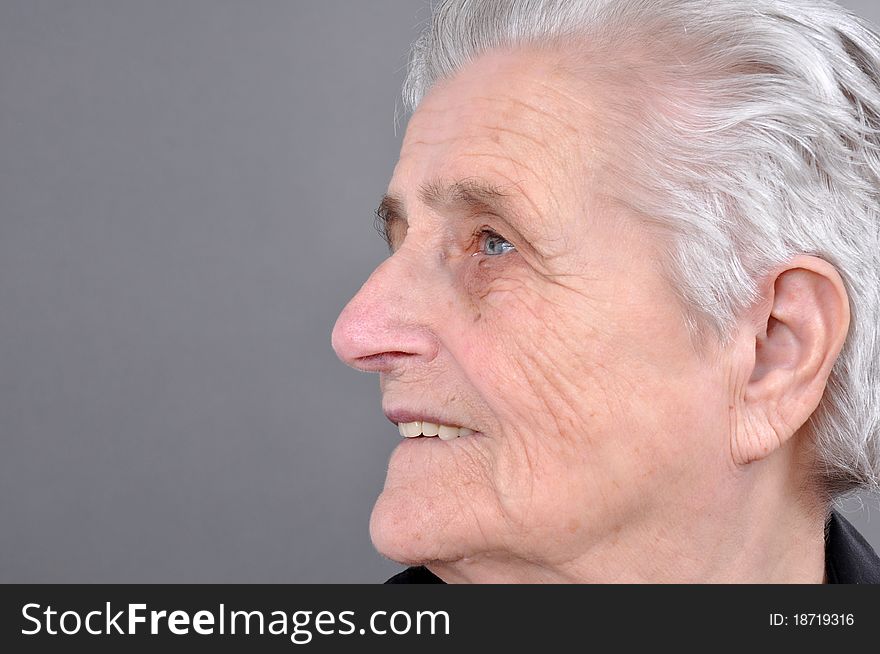 Old, attractive Caucasian woman looking off into the distance.