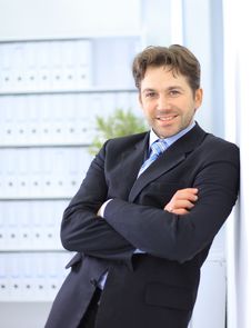 Young Businessman Standing In Office Stock Photo