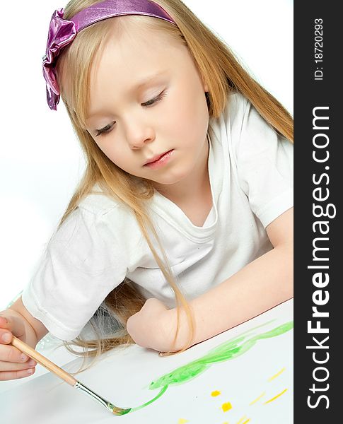 Cute little girl with a brush and paints