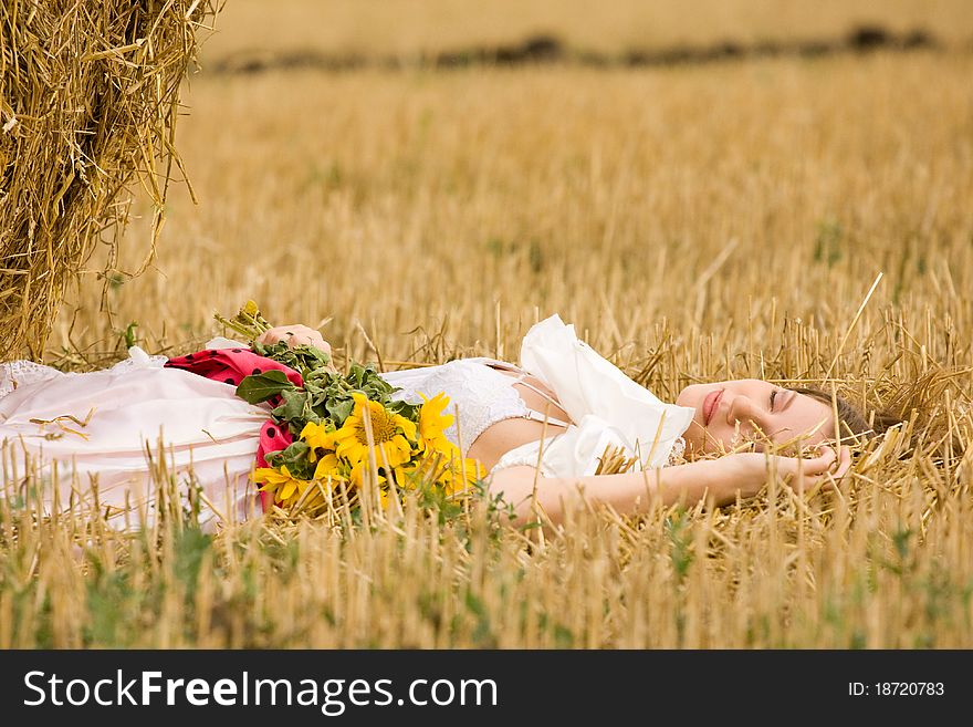 Woman in dress with flowers in the field. Woman in dress with flowers in the field