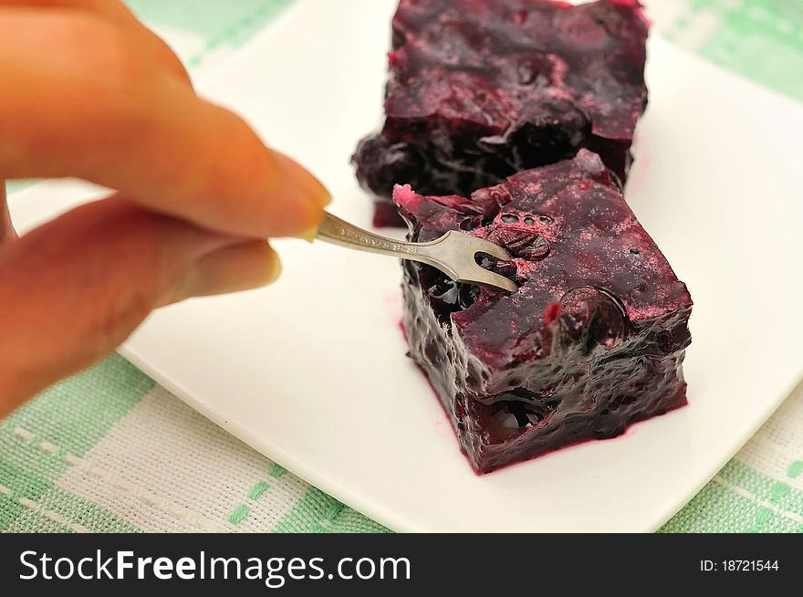 Hand picking jelly with fork