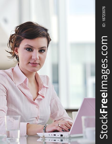 Happy young business woman working on laptop computer at group team meeting at modern office. Happy young business woman working on laptop computer at group team meeting at modern office