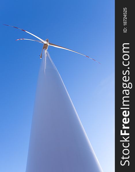 An image of wind turbine against blue sky