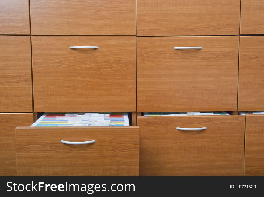 Open shelves made of wood with folders. Open shelves made of wood with folders